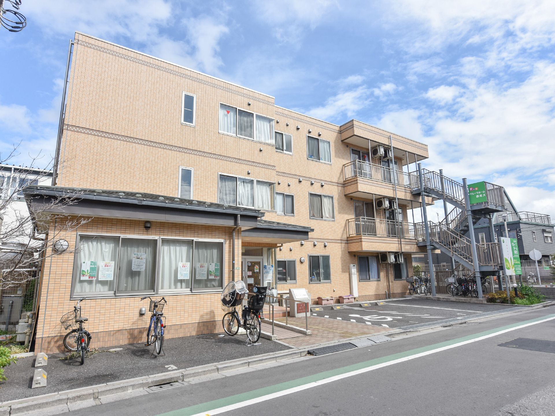 施設は通りに面したクリーム色の三階建の建物。ベランダや非常階段があり、玄関付近の一階部分はせり出す形で三角屋根になっている。