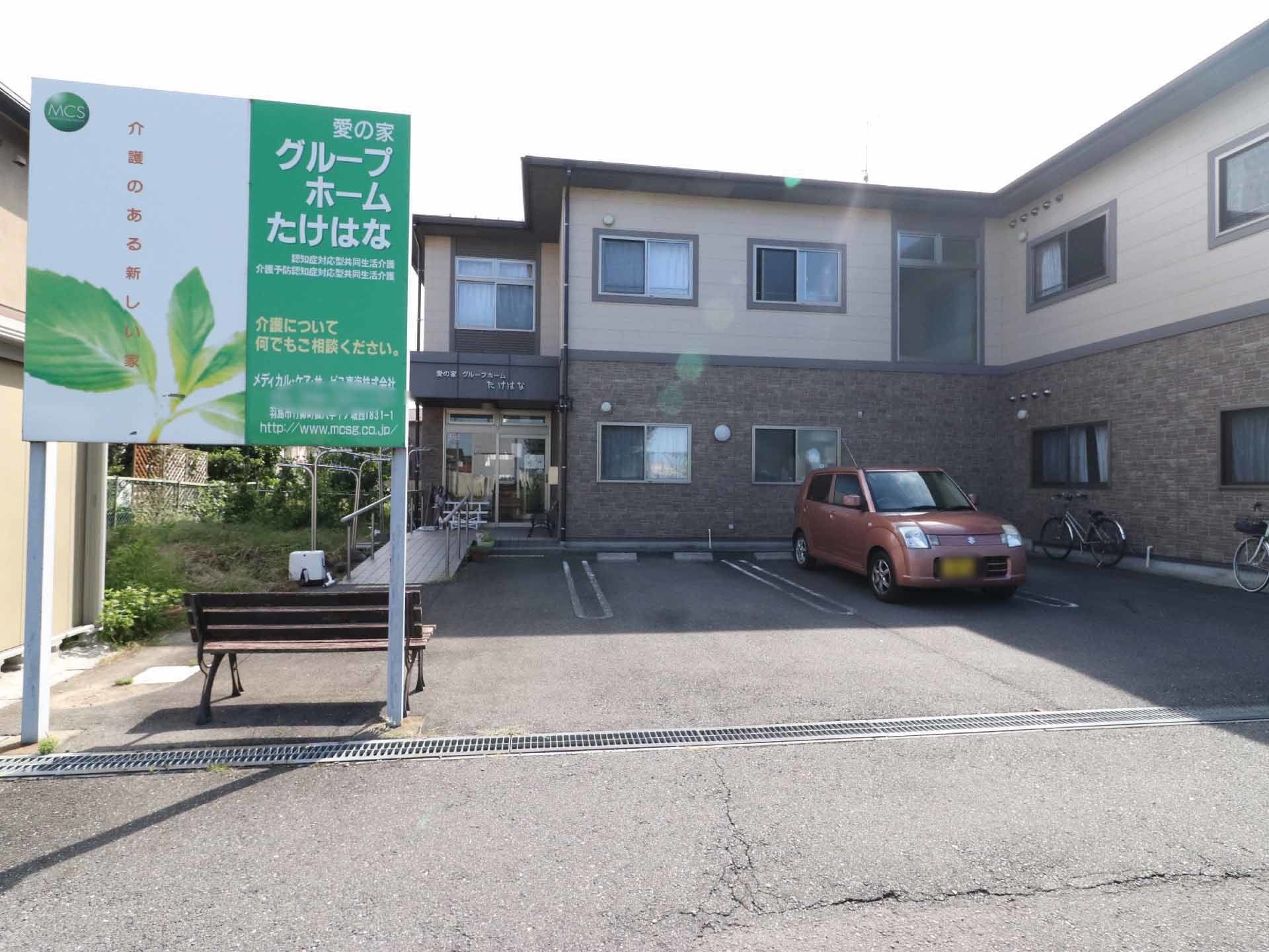 施設の建物は2階建てで、敷地内には駐車場が備わっている。玄関前には階段があり、スロープも設けられている。