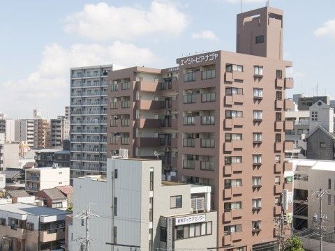 ブラウンの10階建ての外観は、まるでマンションのような造りである。周辺は、高層ビルが建ち並び利便性の高い環境である。