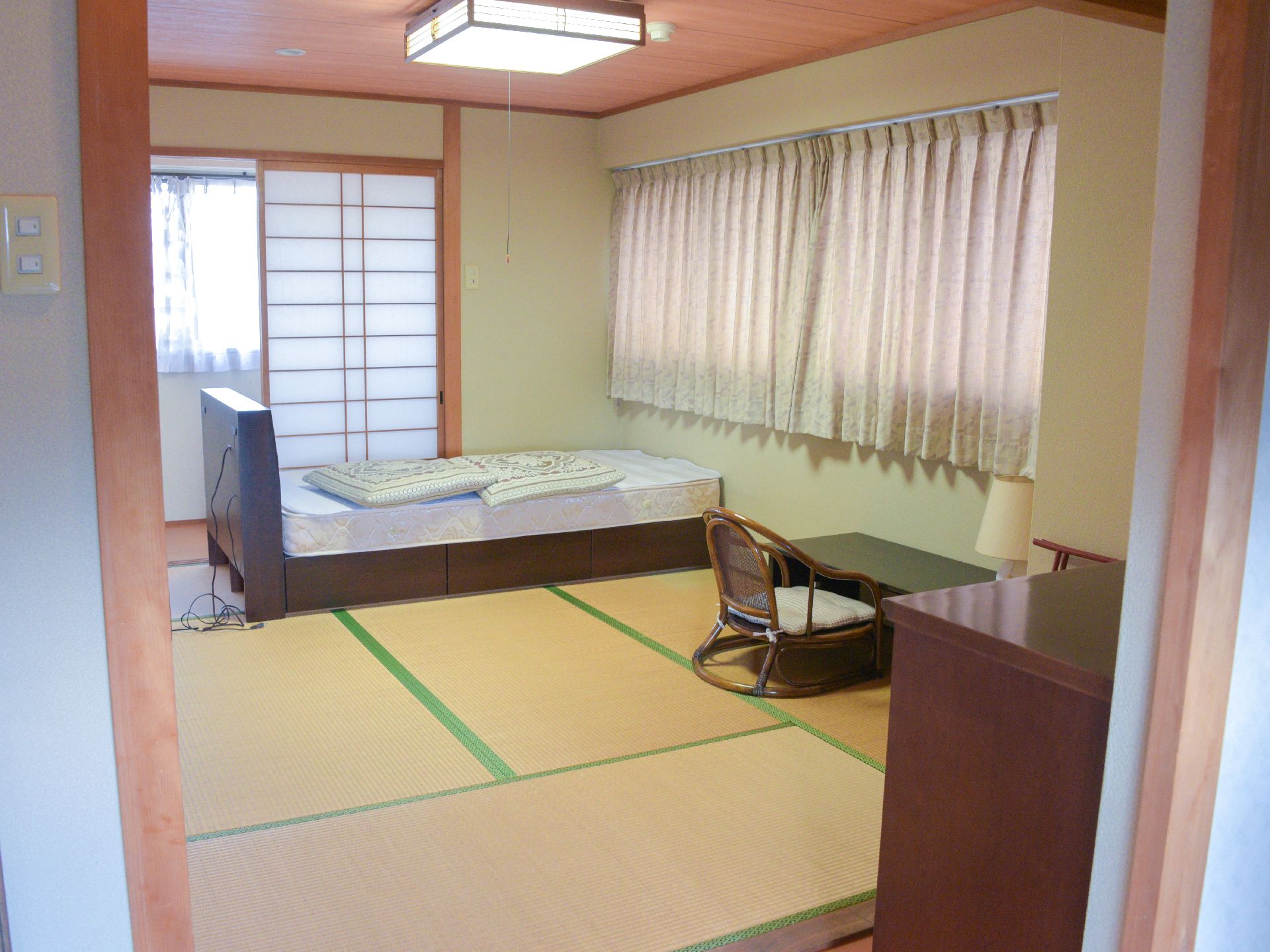 障子のある和室の居室。介護用ベッドと和室用の机が完備されている。畳なのでゆっくりと座ることができ落ち着く。