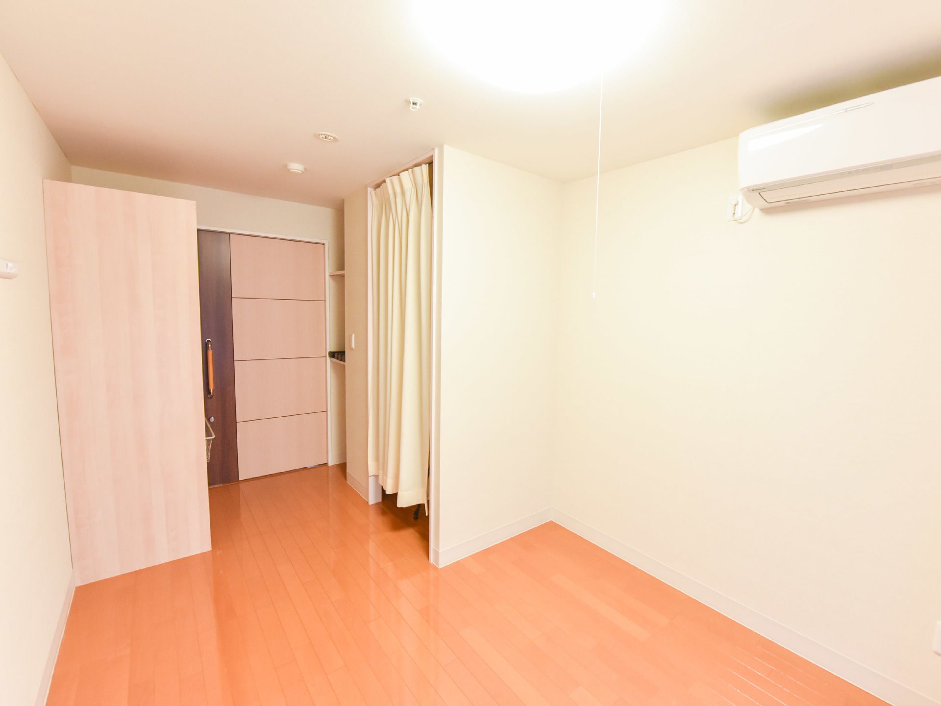 入居された方が生活する部屋には、エアコンが取り付けられている。また、室内にあるトイレはカーテンで仕切られている。