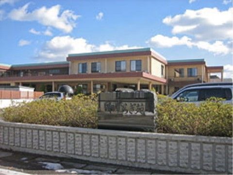 2階建てのベージュを基調とした施設である。玄関前には駐車スペースもあり、ご家族が来訪しやすくなっている。