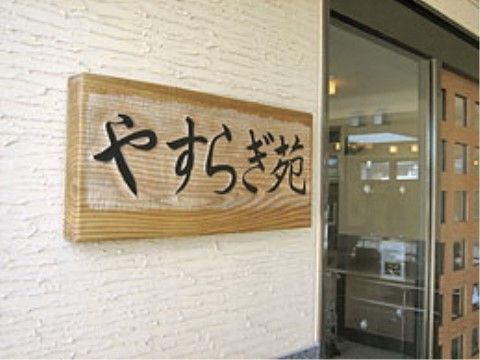 エントランスには、施設の名前が書かれた木の看板がある。ゆったりと流れるような文字からも安らぎが感じられる。