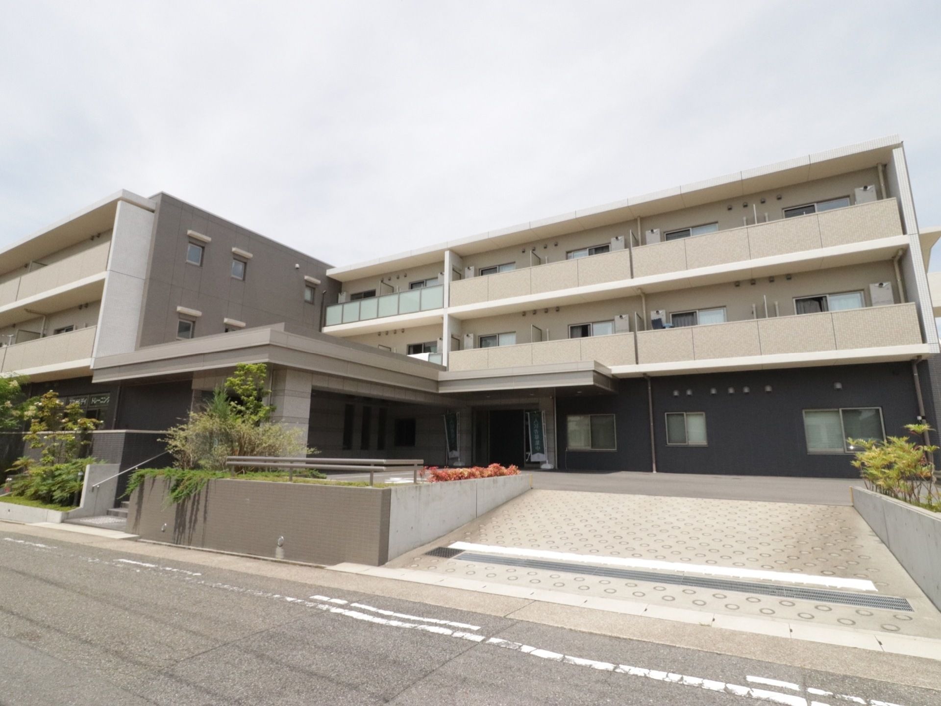 優しいアイボリーとグレーのモダンな2色を使用した外観の施設は、スタイリッシュな高級マンション風である。