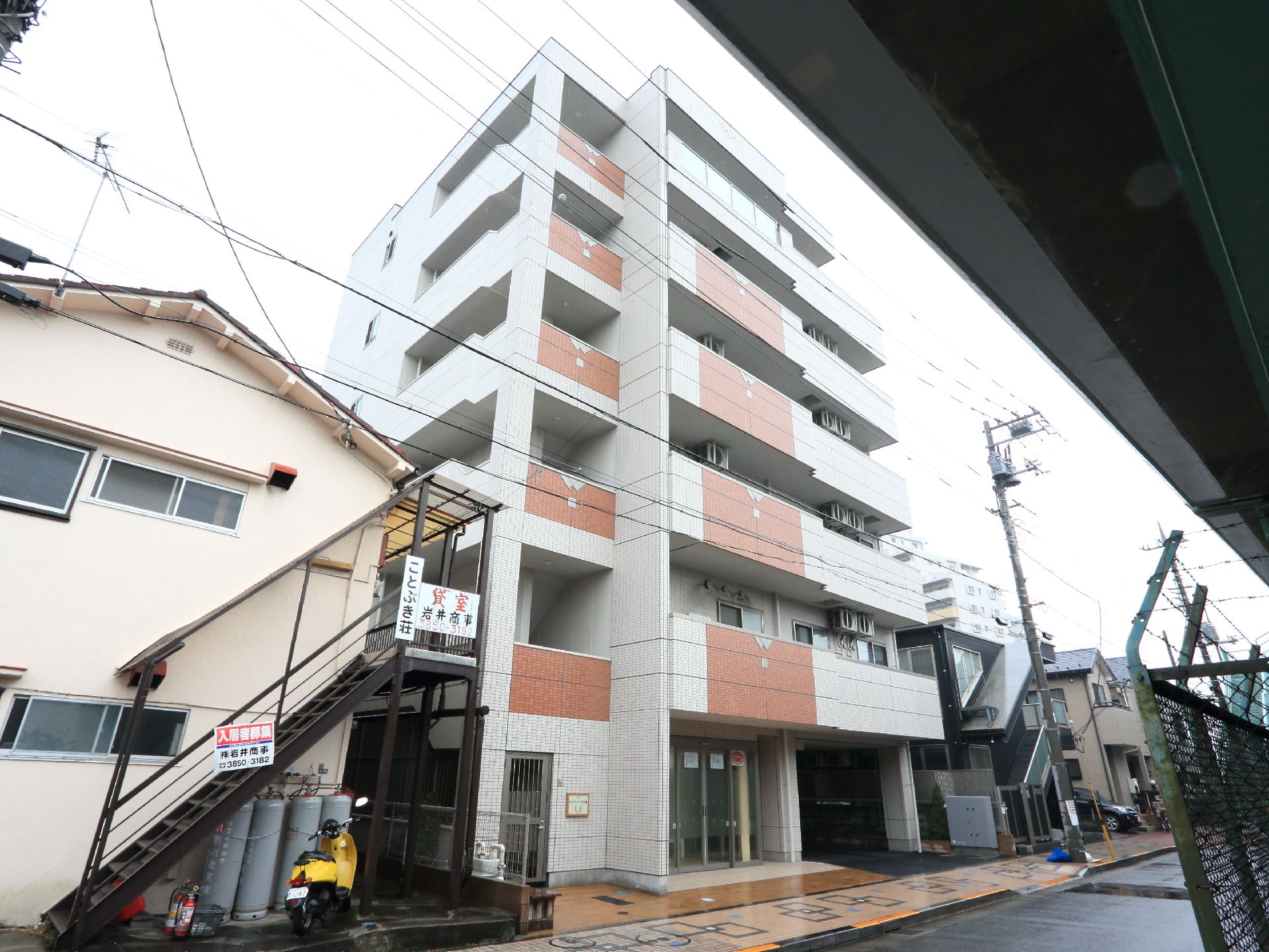 6階建てのこの施設は、アパートや民家の並ぶ通りに建てられている。正面にはベランダが並んでいる様子が見える。