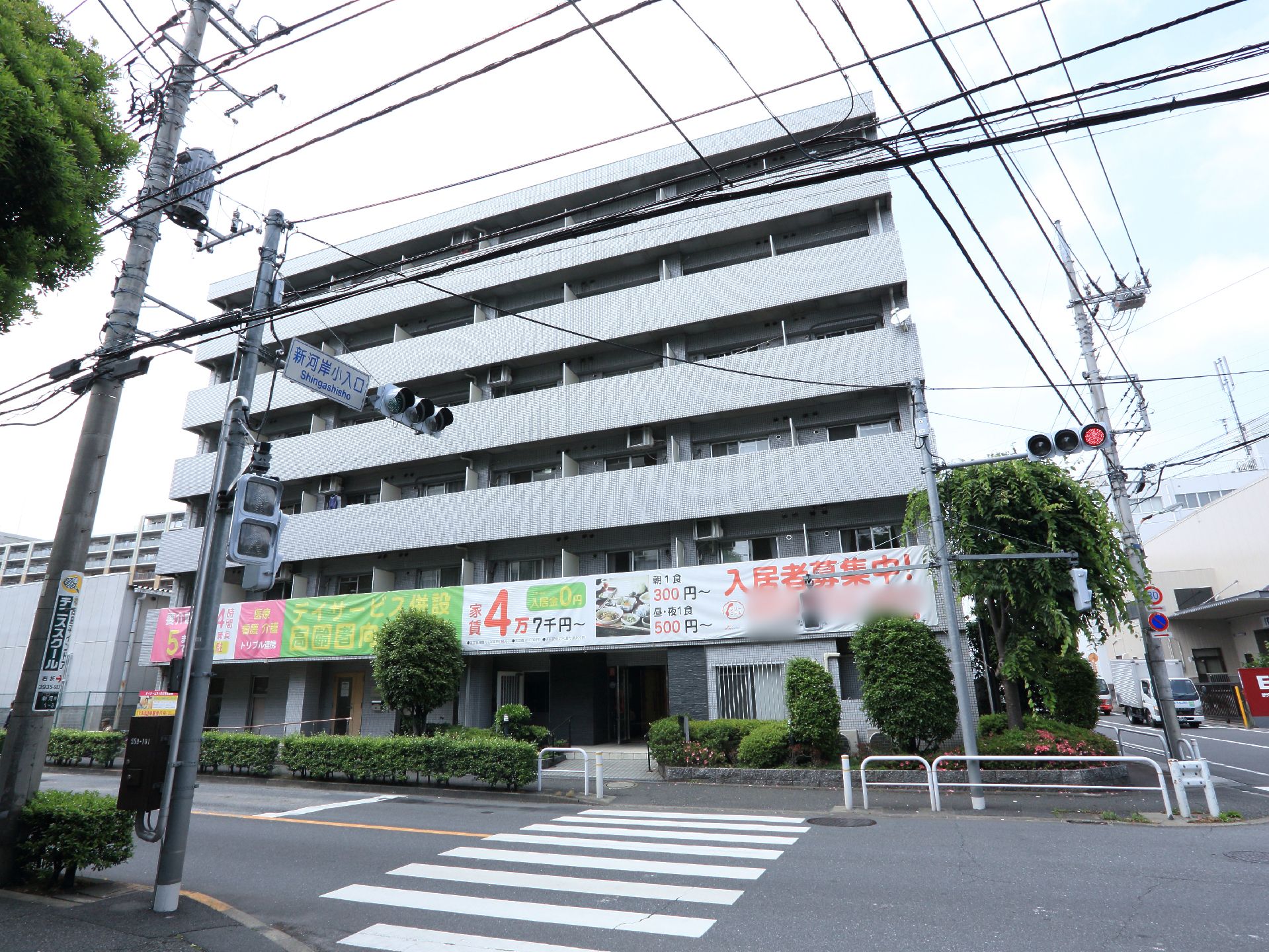 施設には入居者募集中のポスター幕が張られているので、介護施設であることが分かりやすい。目の前に大きな道路がある。