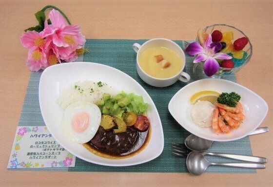 ロコモコライスとガーリックシュリンプ、ポテトサラダとコーンスープ、花を添えたフルーツのデザート
