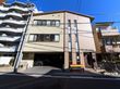 ３階建ての建物で、壁の色は茶色である。１階は玄関と駐車場になっている。道路に面してベンチが置かれいる。