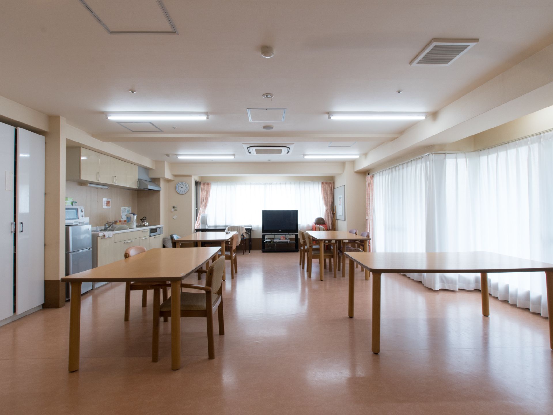 広々とした空間に机が並んでいる。机の間隔は広く、歩きやすい。2面に窓があって太陽光がふんだんに差し入れ、明るい。