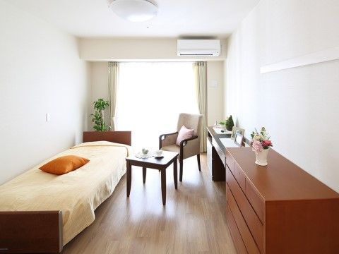 大きな掃き出し窓があり、白い壁からなる部屋は、清潔感がある。木の温もりを感じられる調度品で統一し、穏やかに過ごすことができる。