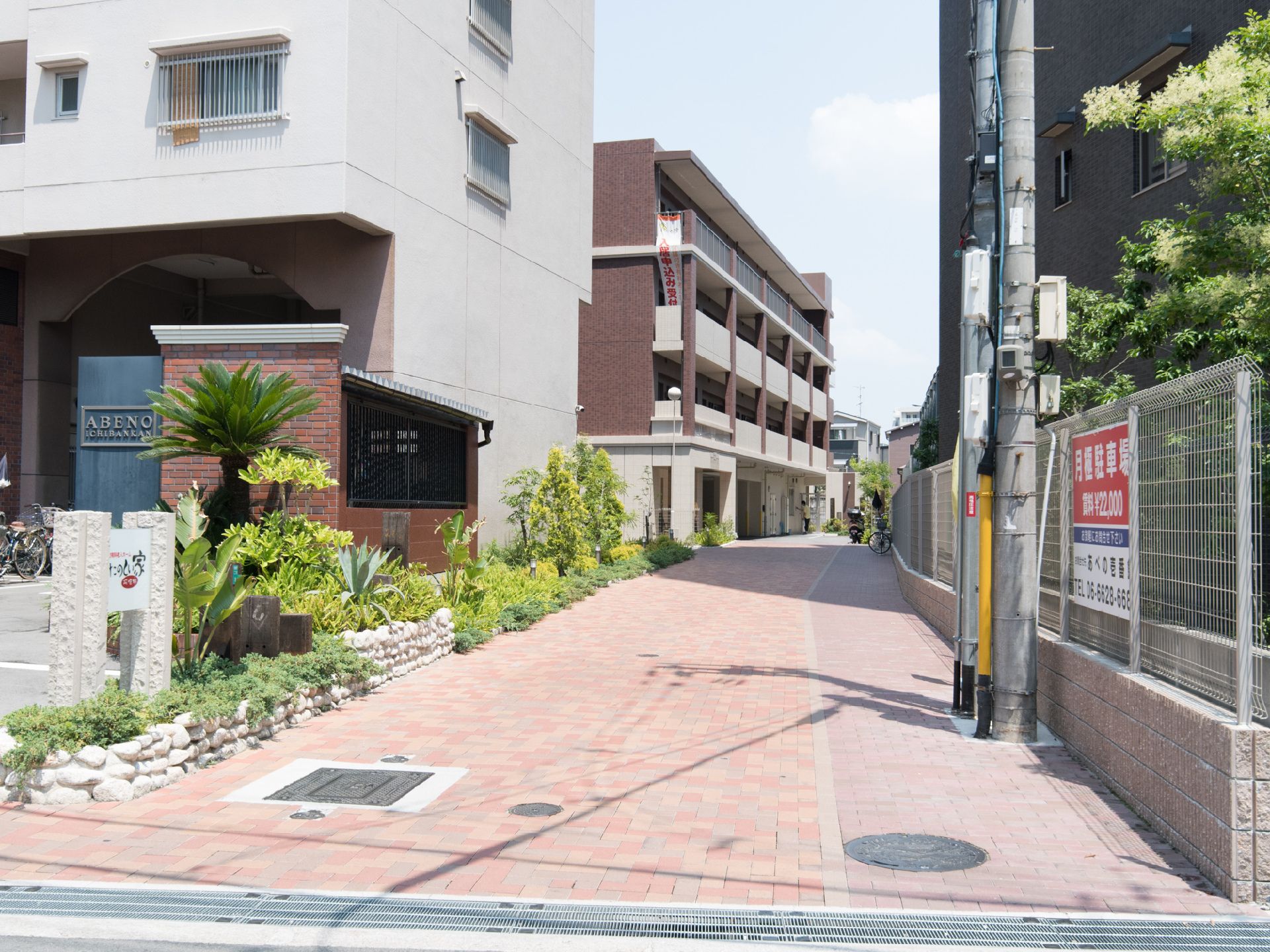公道から入り施設へと至る道路は私道となっている。アスファルトやコンクリートではなく赤系の舗装ブロックが敷き詰められる。