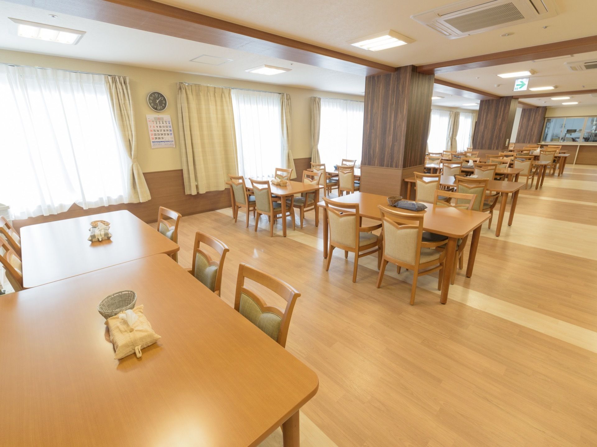 木目調を基調にゆったりスペースを確保した食堂である。車椅子ご利用の方も安心してテーブルにつくことができる。