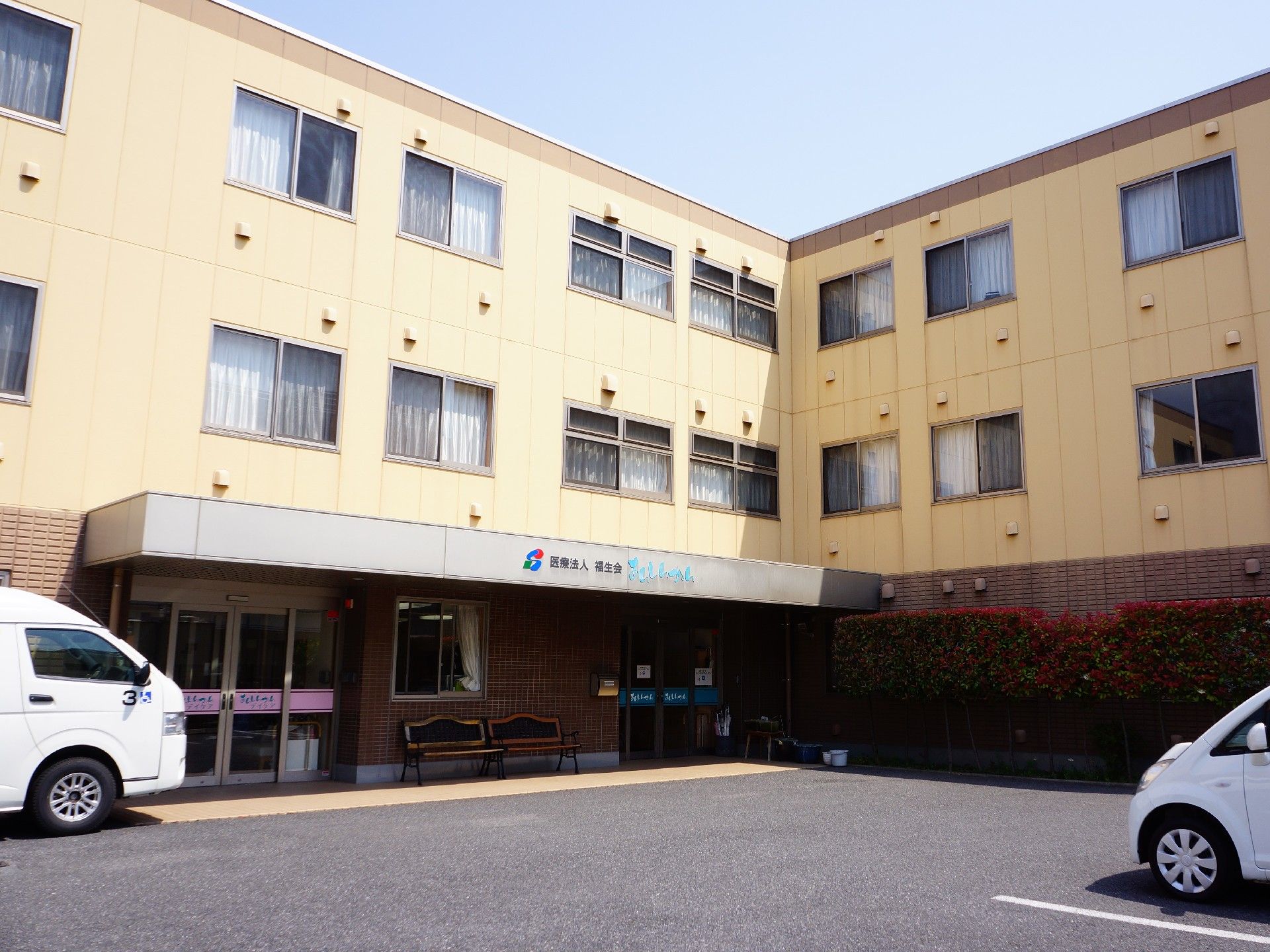 クリーム色の3階建てのホーム。敷地内に駐車場を完備している。