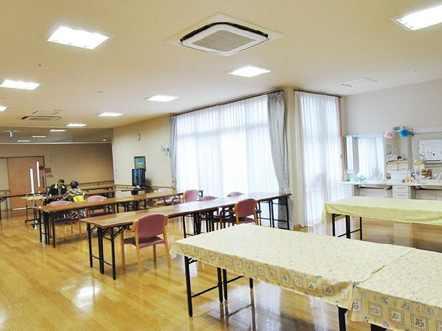 長机と椅子が並べられ、テレビが設置されている。食事以外にも、交流の場として利用することができる。大きな窓があり、明るい雰囲気である。