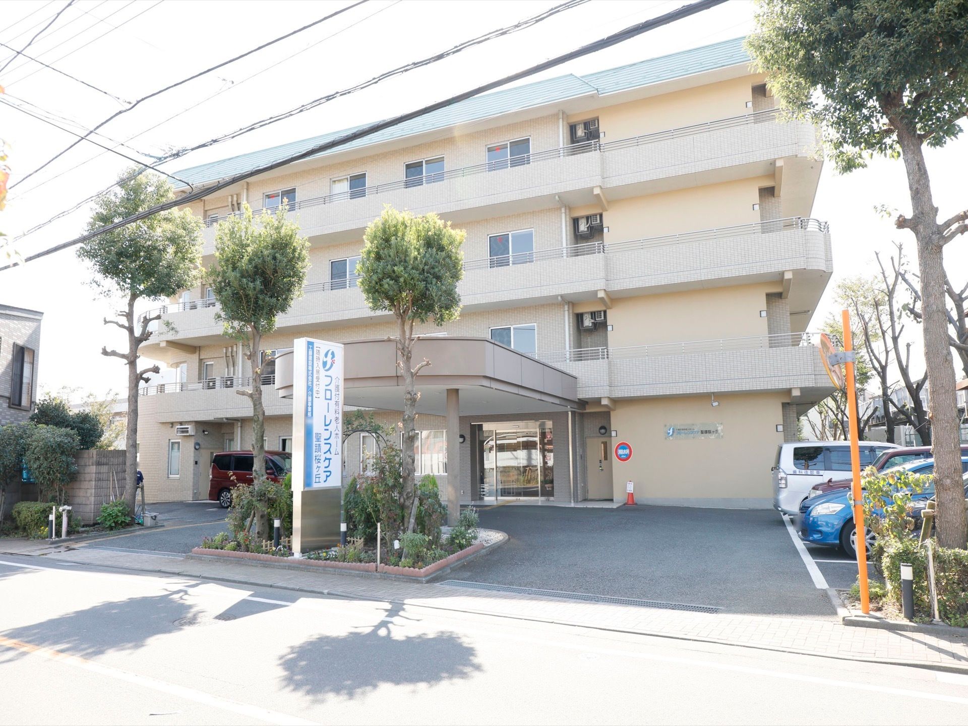 施設は4階建ての建物である。アイボリー色の外壁で周辺環境に馴染んでいる。木が周辺に植えられて緑を感じることができる。