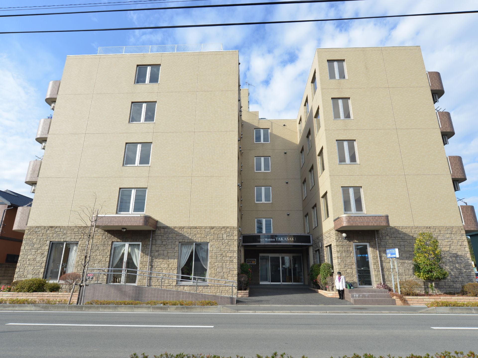 5階建てのコの字型のベージュ調の建物です。コの字の凹んだ部分、左右の棟それぞれ道路に面した部分ん出入口があります。