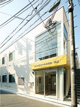 施設名の立体文字が見える、2階建てアパート型のグループホームの入口