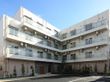 広々とした駐車場が設置された、４階建ての施設の外観