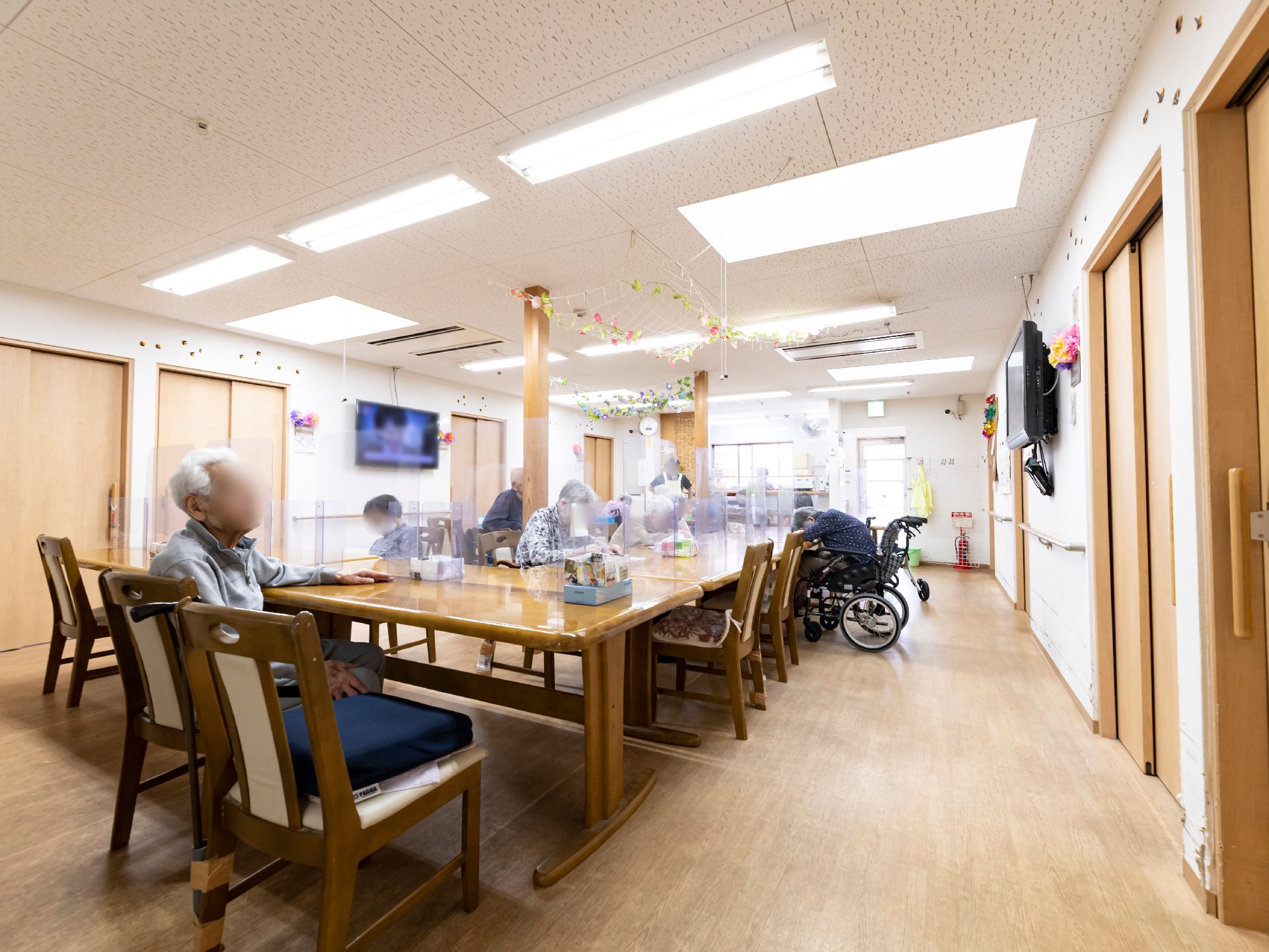 椅子と仕切り板がついているテーブルが設置された共有スペース