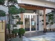 建物の入り口には、きちんと手入れされた植栽がある。玄関の屋根は、木で作られていて、ほっとさせられる。