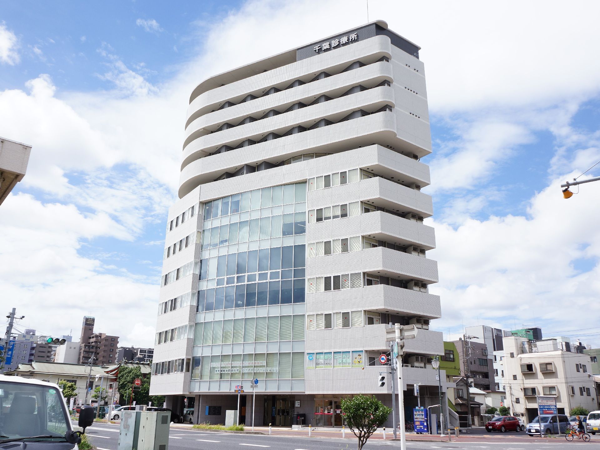 道路に面した場所に施設が建てられている。施設は12階建になっていて、ガラス張りと白い外壁の作りになっている。