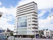 道路に面した場所に施設が建てられている。施設は12階建になっていて、ガラス張りと白い外壁の作りになっている。