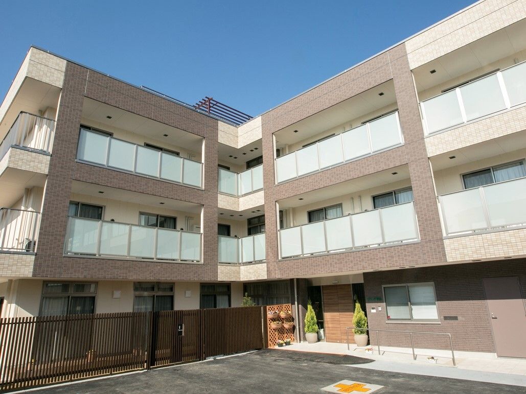 各階ベランダを完備した、茶色とベージュを基調としている3階建ての建物