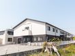 白と茶色を基調とした２階建ての介護施設の外観