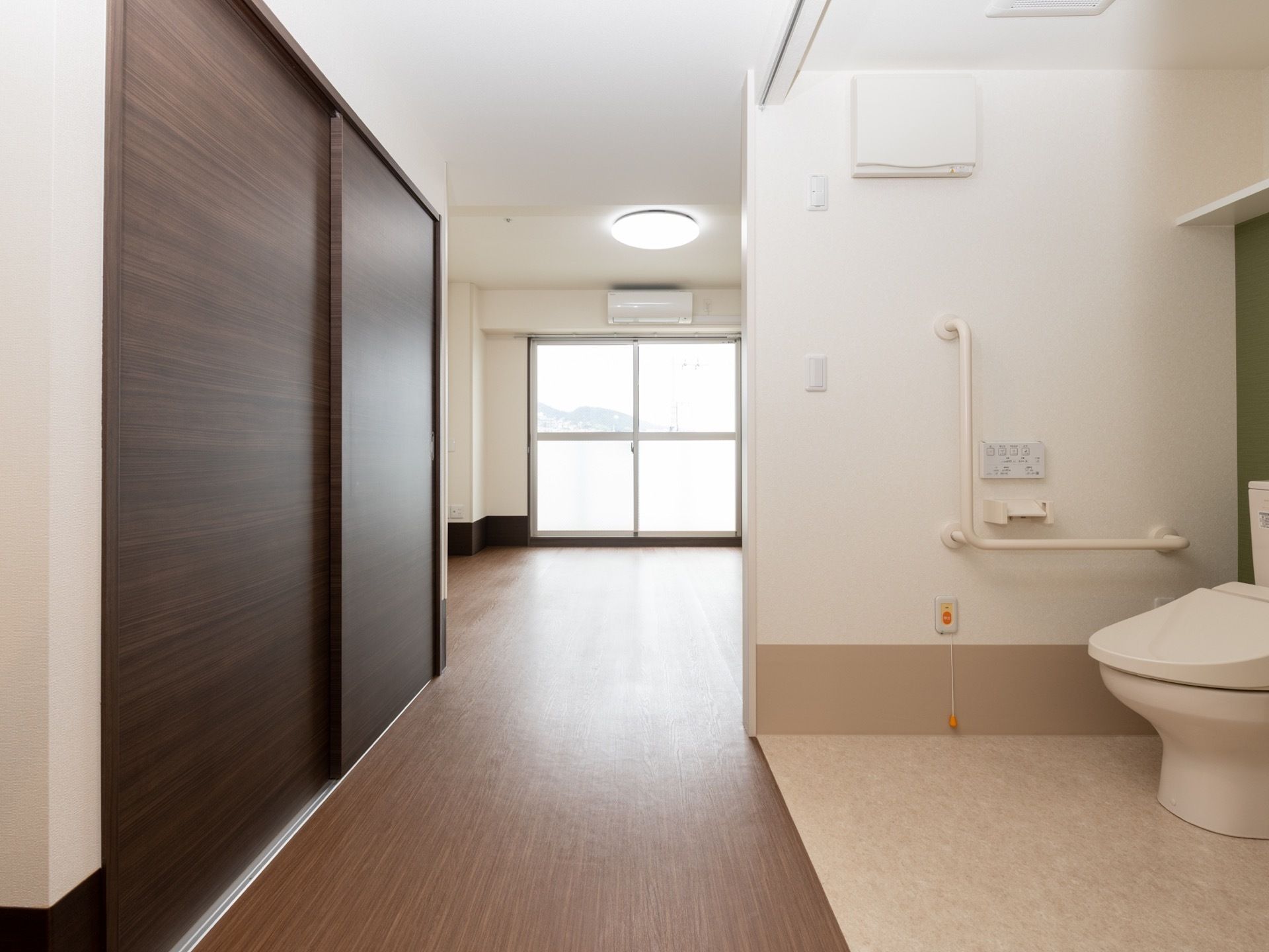 部屋に入ると左手に押し入れタイプの収納があり、右手にトイレがある。廊下の奥に居住スペースが広がっている。