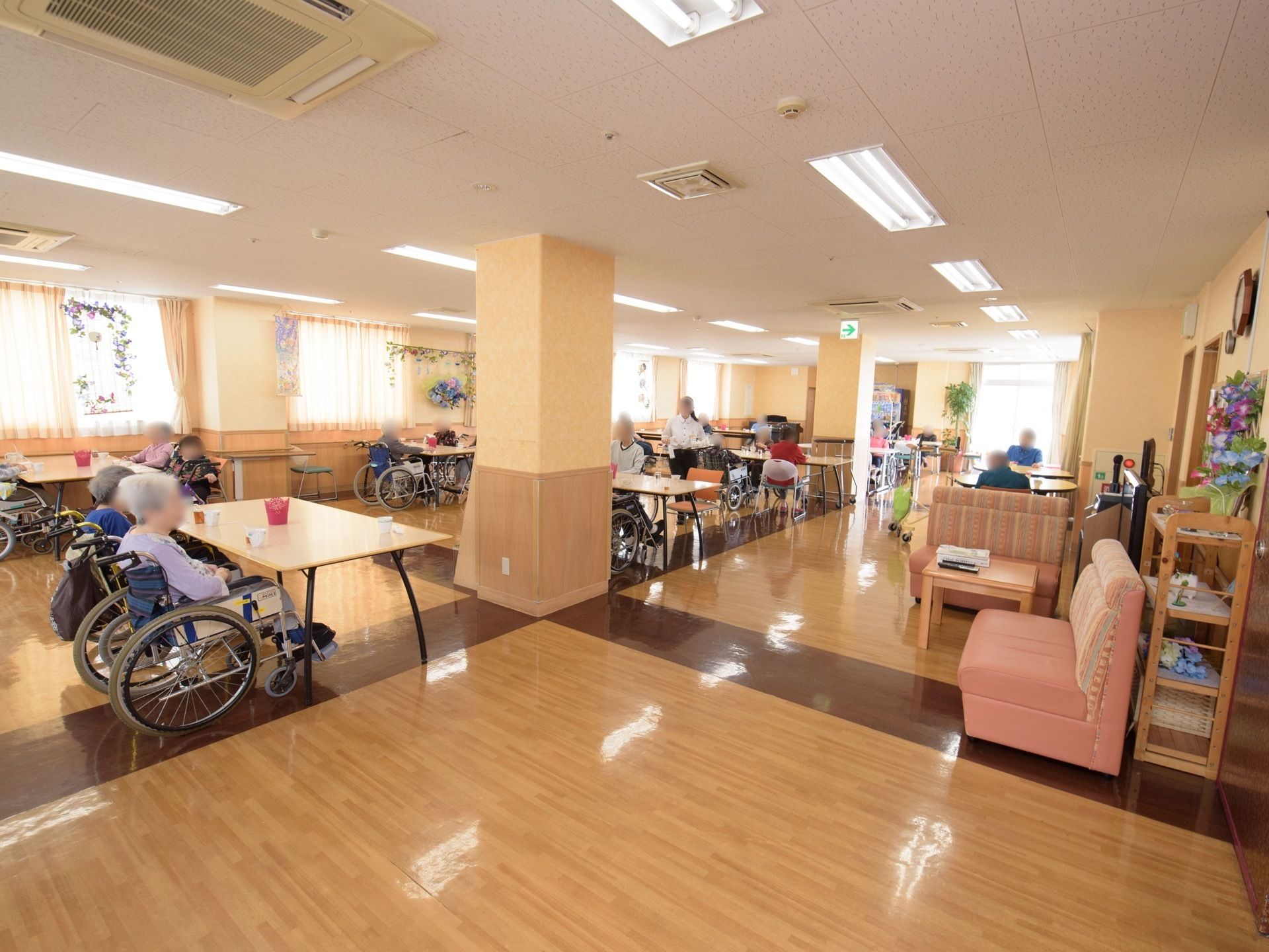 腰高窓が続く、広い空間である。窓にはカーテンが掛かっており、天井にはエアコンが数台埋めこまれている。