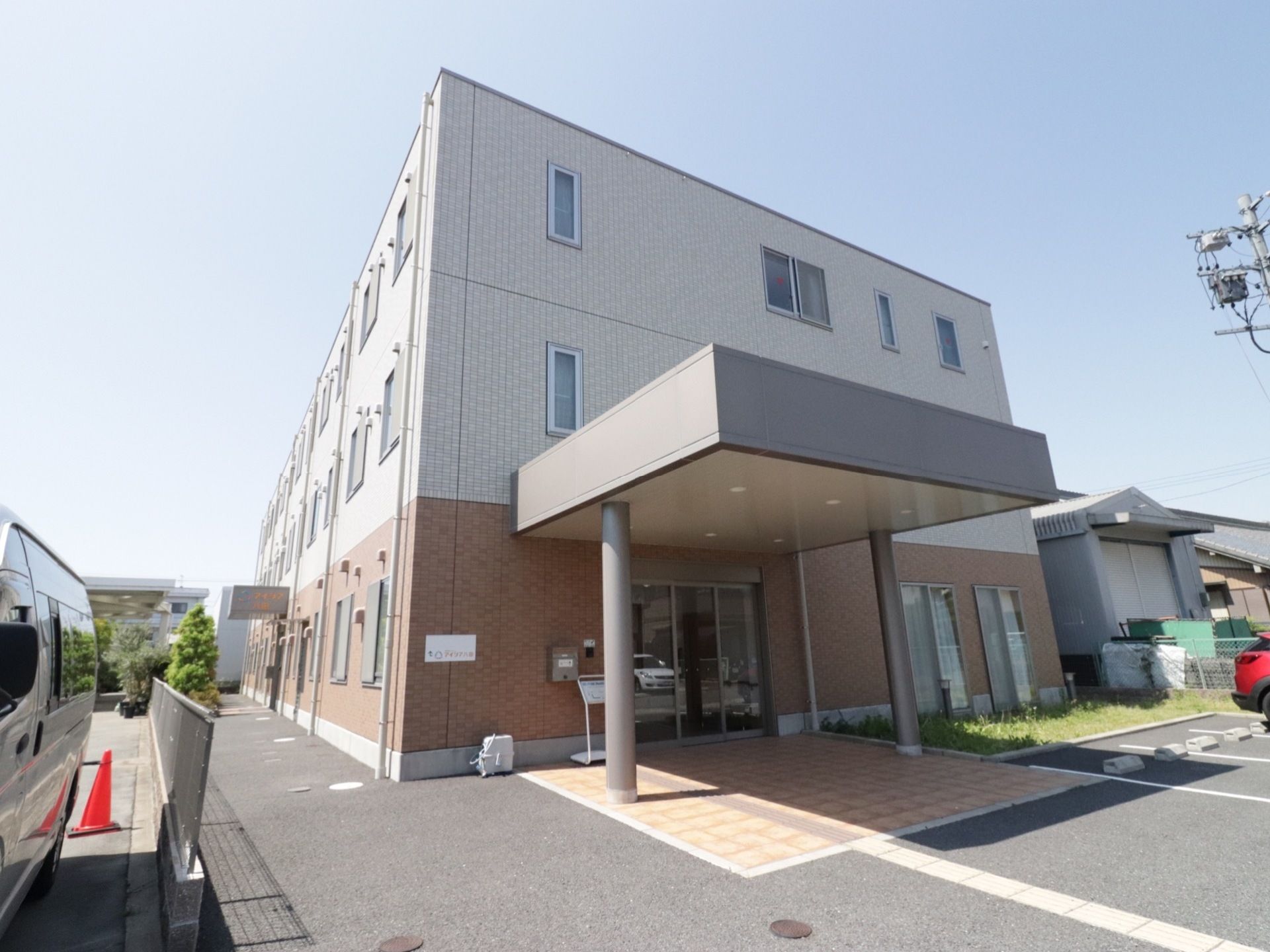 一階はベージュ、二、三階はアイボリーの明るい外観の建物で、玄関すぐ横の駐車場からは段差なしで入館することができる。