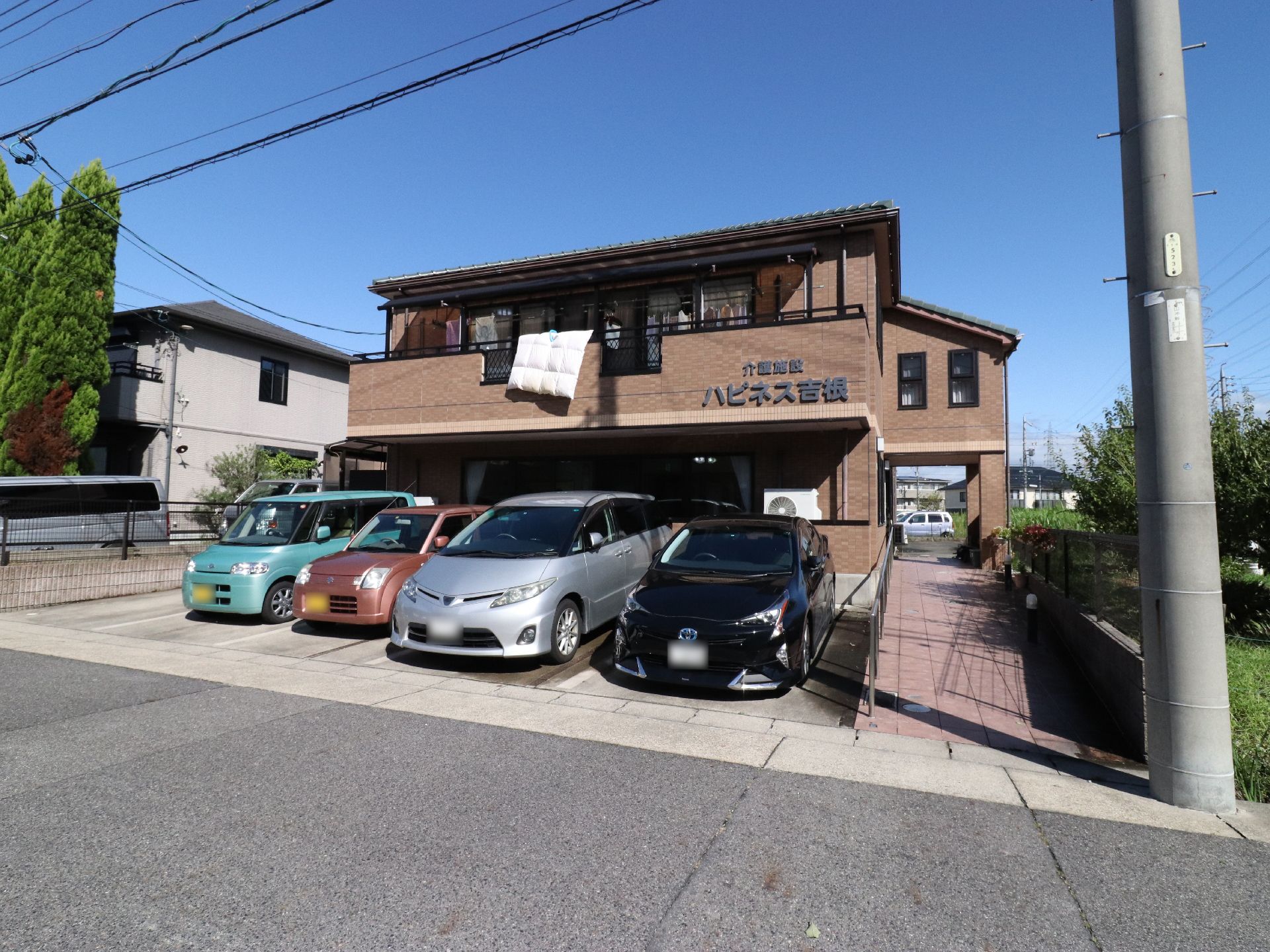 施設はレンガ調の外壁である。駐車場から玄関まで手すり付きのスロープが設置されている。ベランダが1階2階共にある。