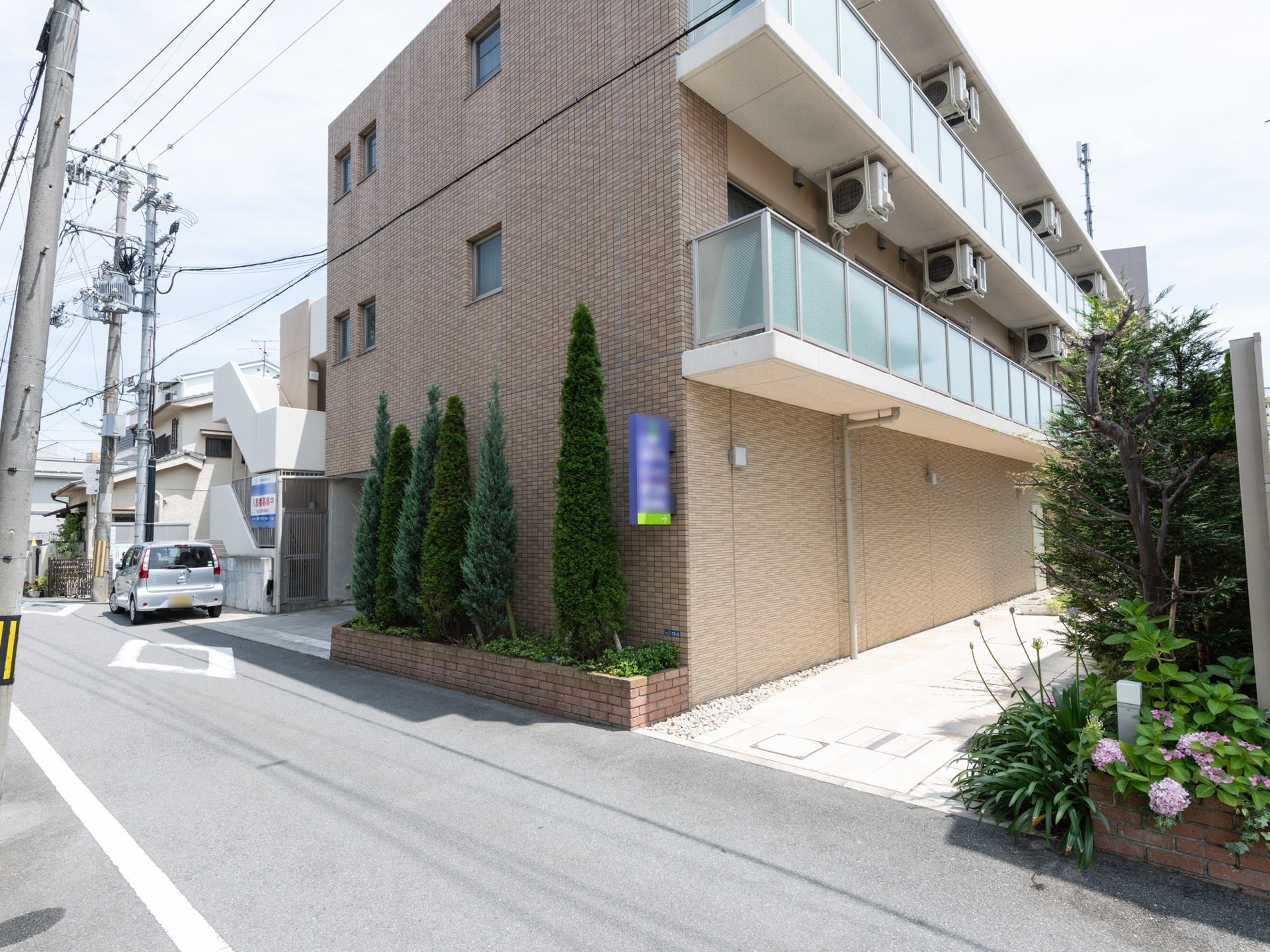 地上３階建てで全室にベランダとエアコンが設置されている。施設の敷地内には多くの木々が植えられている。