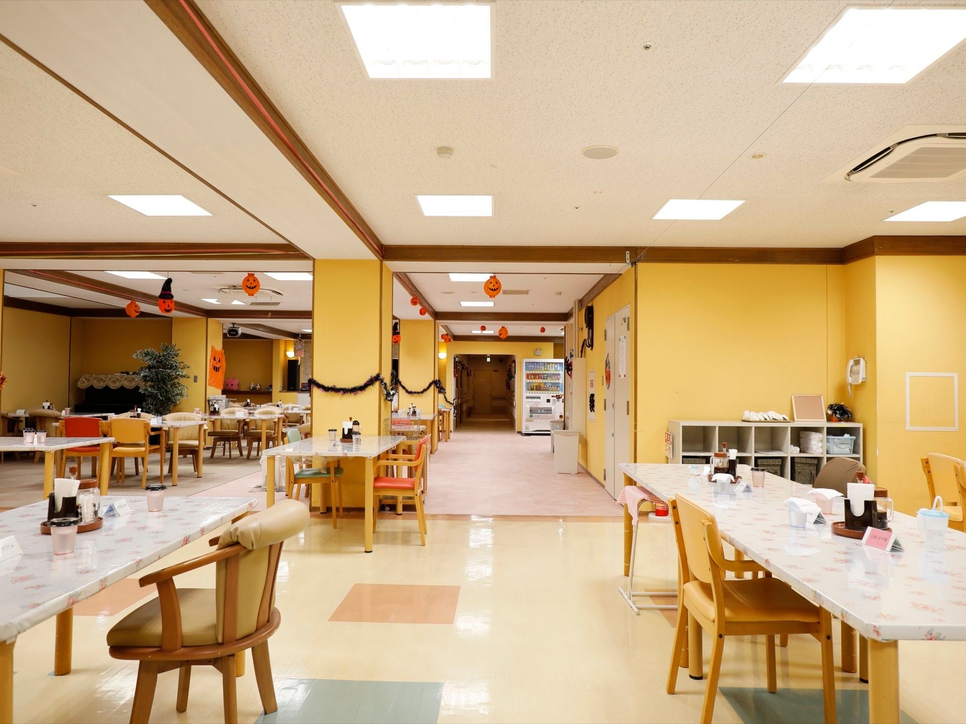 広い食堂に、多くの椅子やテーブルが置かれている。飲料の自動販売機が設置されている。季節のイベントの飾りつけも行われている。
