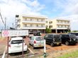 施設周辺には高い建物がなく、日当たりが良い。敷地内には駐車スペースが設けられており、複数の車が停められている。