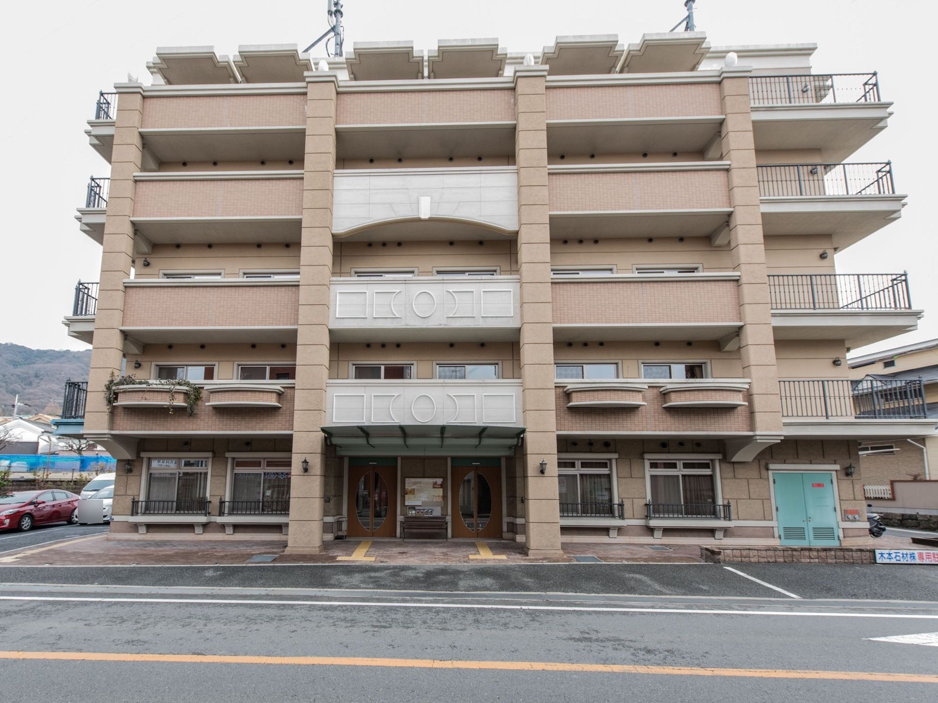 建物の横に駐車スペースが設置されている。遊歩道と敷地との境目に凹凸がない。全室にベランダが設けられている。