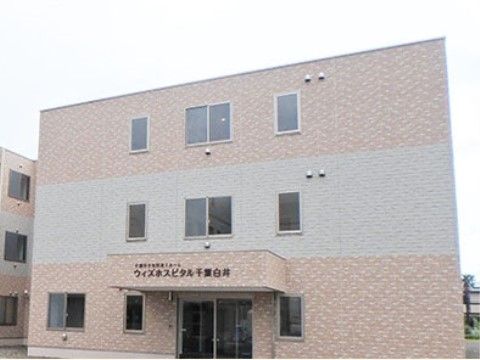 建物は3階建て。壁はベージュ系の色で、1階部分の壁の色が最も濃く、2階部分が一番薄い。外見はシンプルな作りの建物である。