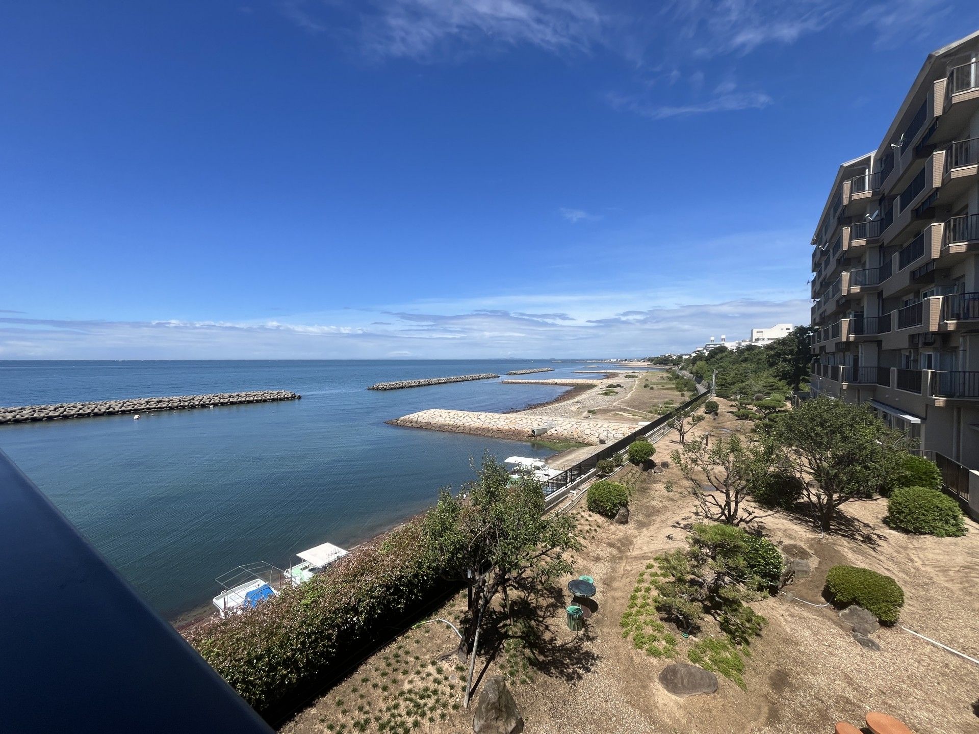 陸上保管された船が並ぶ水辺の奥に建つ、茶色い大きな建物