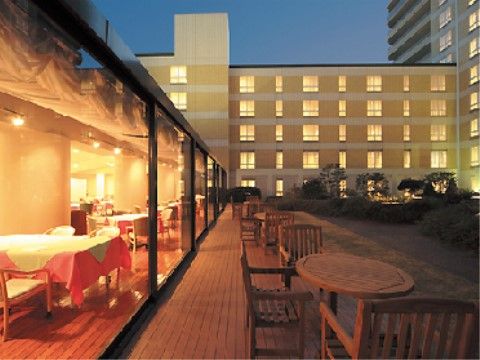 クロスが懸けられた窓際のテーブルが照明で明るくなっている、夜の施設風景