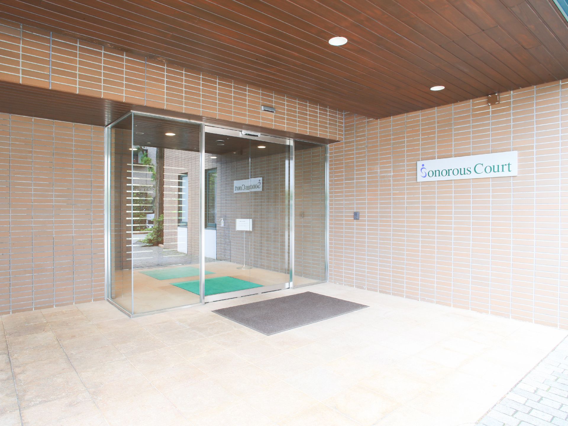 施設の入り口部分には英語表記の施設名の看板が掲げられており、まるで高級マンションのような佇まいを見せている。