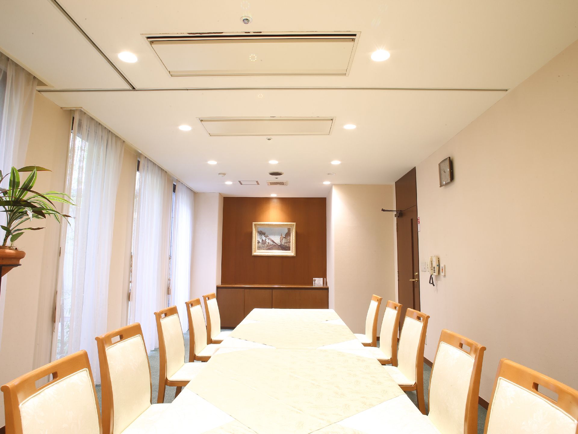 施設内にはホテルの待合室を想起させるような部屋があり、テーブルの左右にイスがたくさん並べられている。