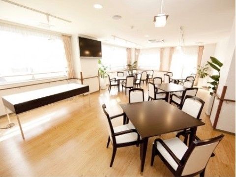 白を基調とした明るい食堂。窓がたくさんあるので日当たりが良く、居心地の良い雰囲気。４人掛けのテーブルがいくつも並べられている。