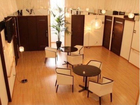 白とダークブラウンを基調にした広い談話室は、暖色系の照明が使われているため、温かみのある雰囲気である。椅子とテーブルが設けられている。
