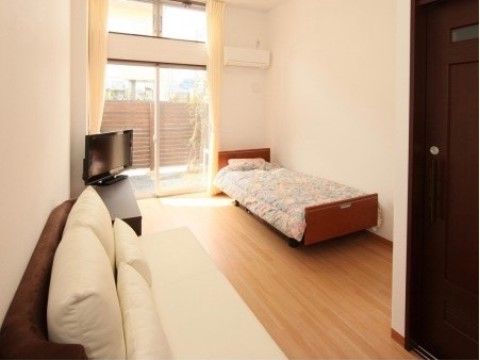 大きな窓から光が差し込み、部屋の雰囲気を明るくしている。また、部屋にはベッドの他にソファもついており、くつろぐことができる。