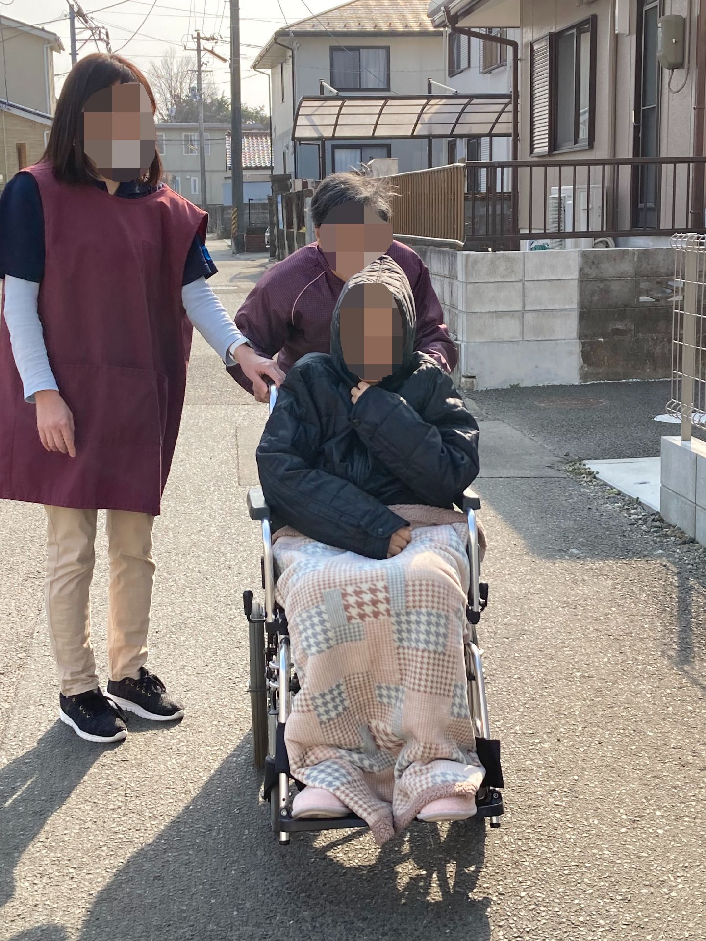 女性ヘルパーと車椅子に乗った高齢男性
