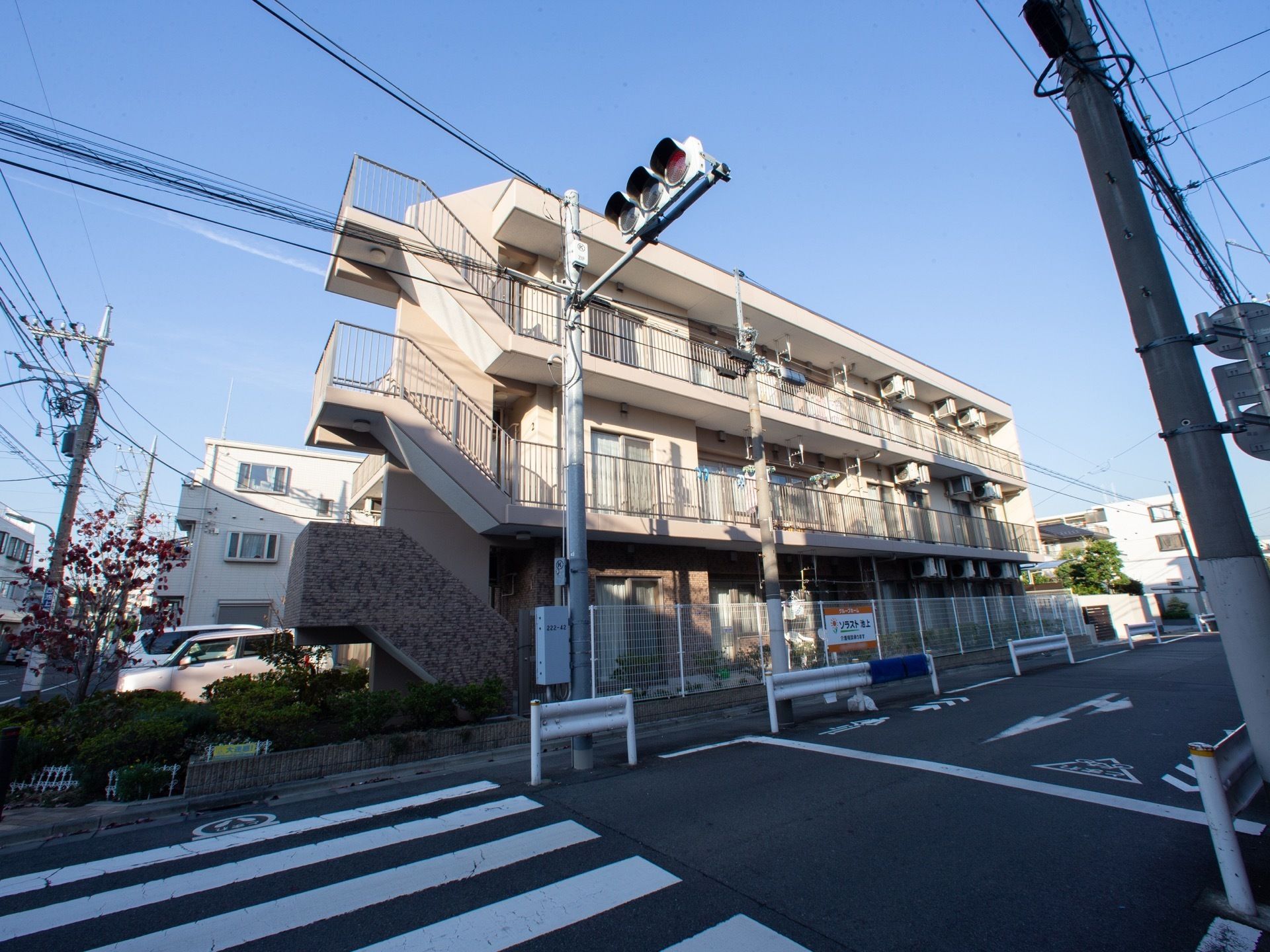 ３階建ての建物になっており、道路に面している。施設内には駐車スペースが設けられており、車が停まっている。