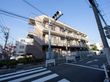 ３階建ての建物になっており、道路に面している。施設内には駐車スペースが設けられており、車が停まっている。