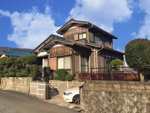 施設は大きな和民家風の外観となっており、1台車が止まっている。敷地内には手入れのされたサツキがたくさん植えられている。