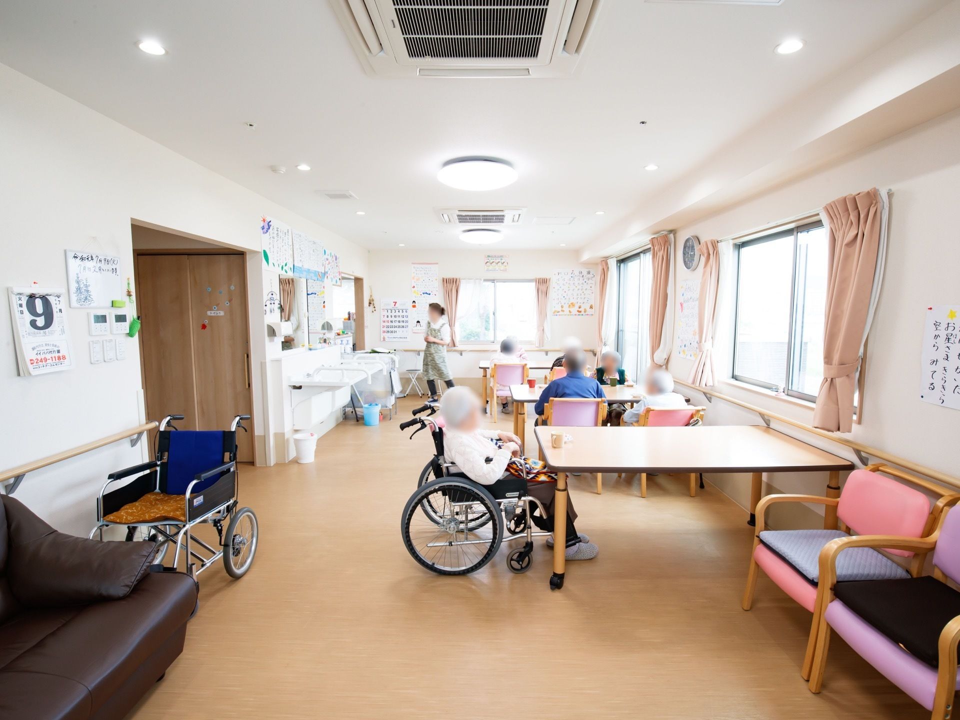 窓に囲まれた明るい食堂。窓際にはテーブルと椅子が置かれており、洗面台がある。同じ空間に談話室がある。