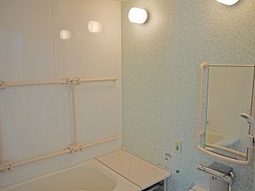 手すりが多くつけられた浴室には、シャワーチェアやベンチもある。一人用の浴槽。